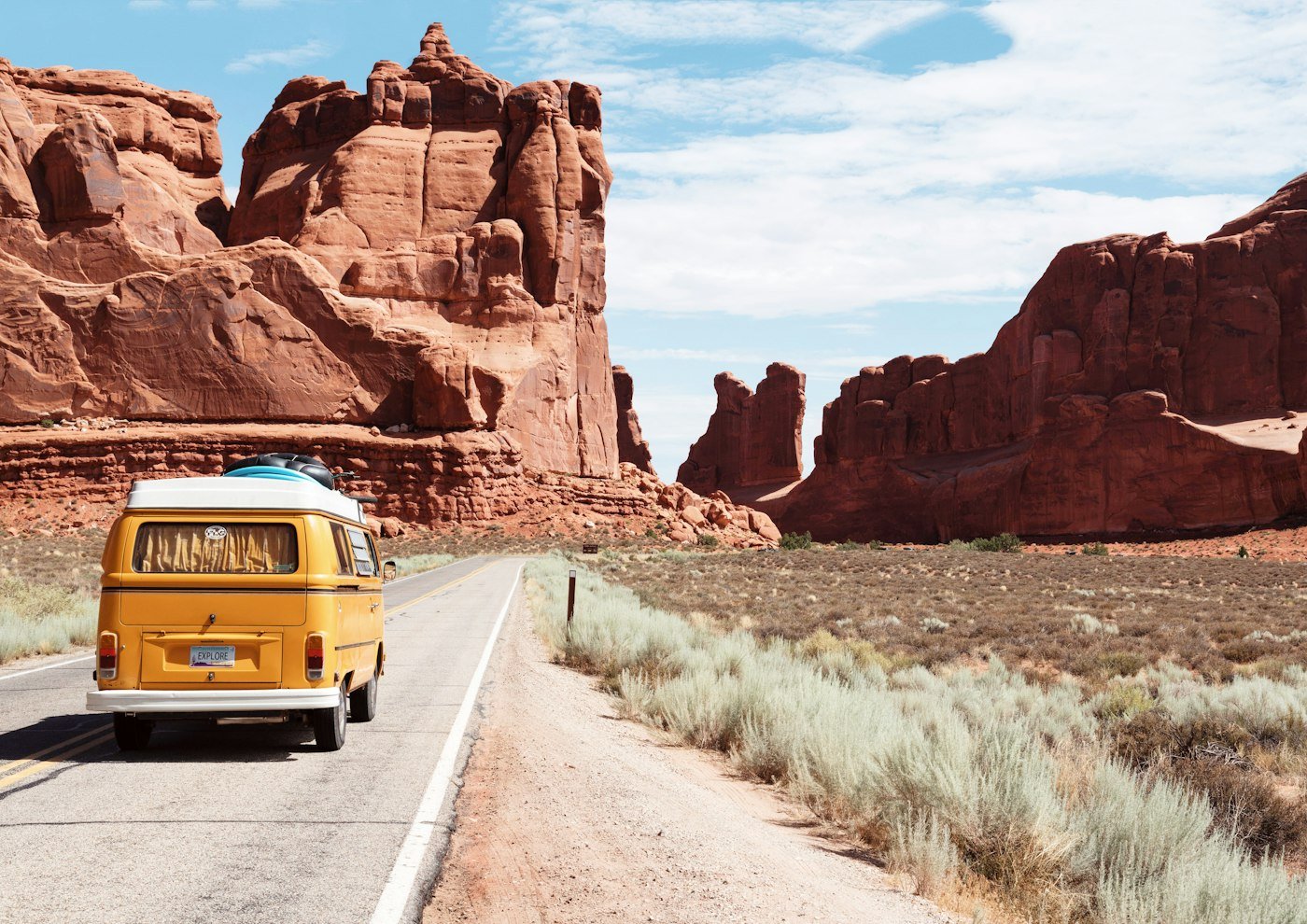 Winding open road leading toward scenic sunlit mountains and nature
