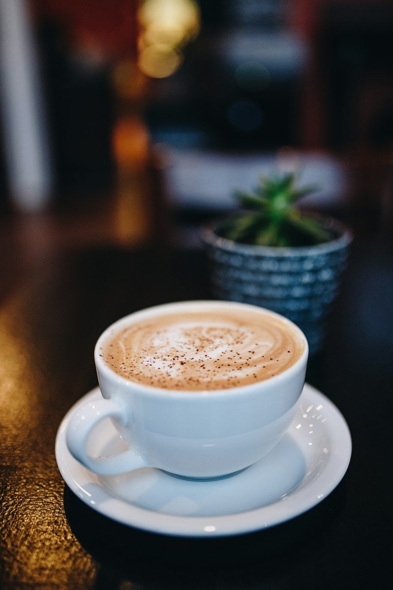 Two ceramic coffee mugs on a warm wooden table during an intimate conversation